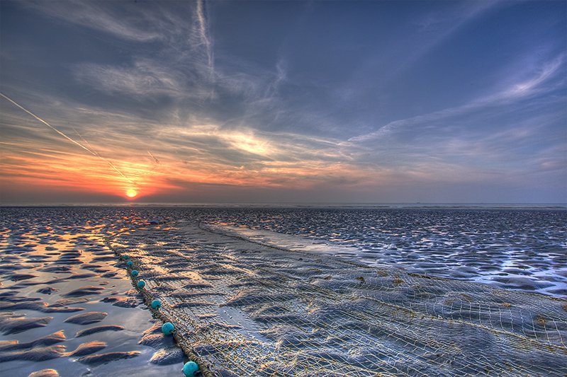 kuieren met zonsondergaan aan het strand Nieuwpoort